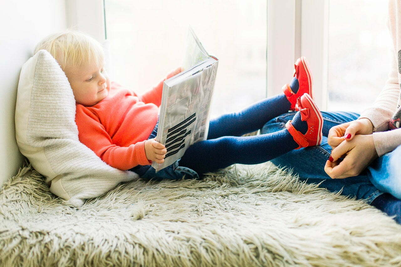 a person sitting on the floor reading a book