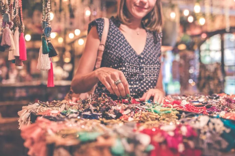 a woman standing next to a table full of colorful candies