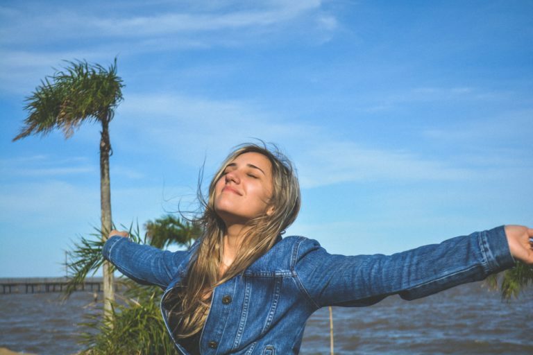 a person standing next to a body of water with a palm tree