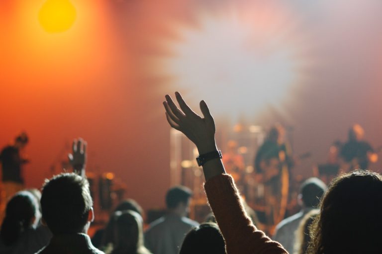 a person holding a microphone with a crowd watching