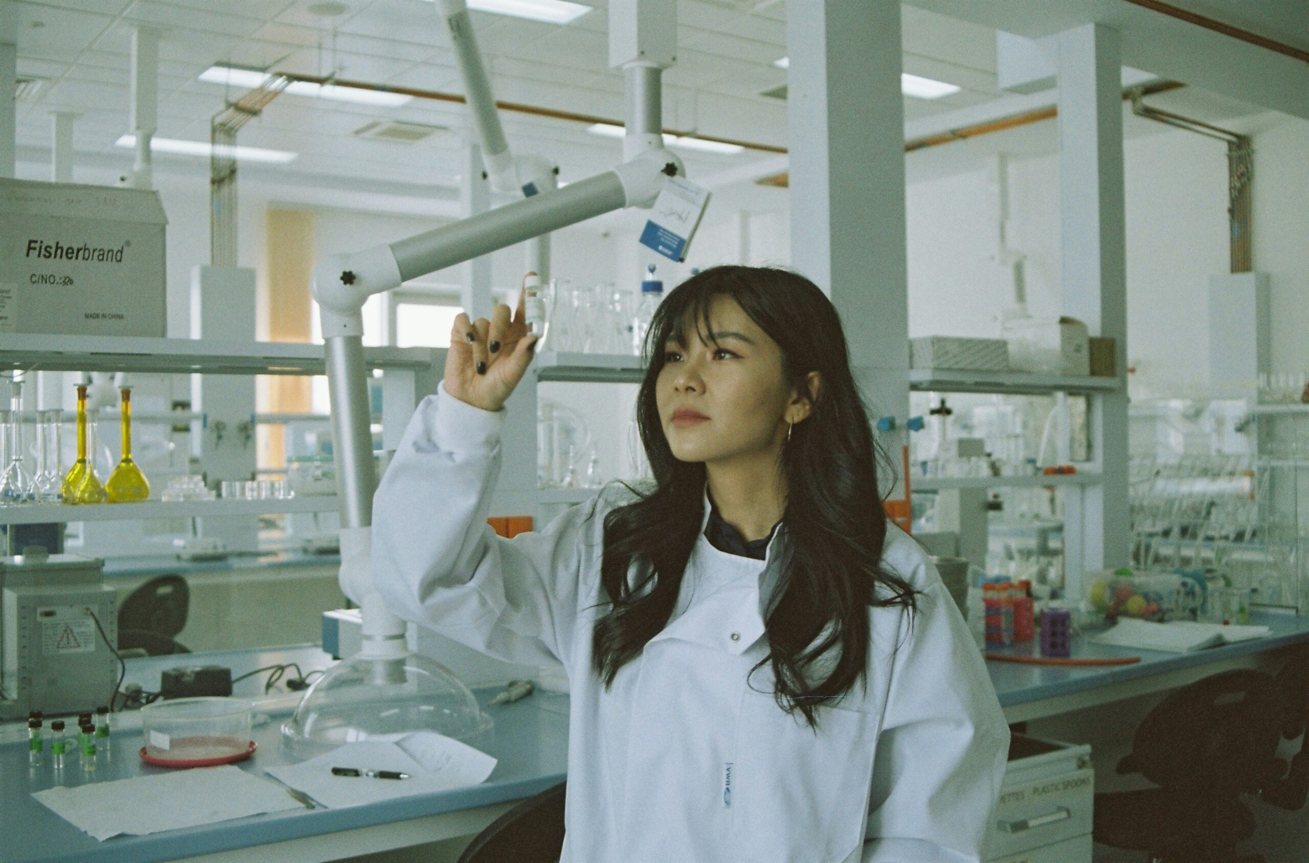 a woman in a lab coat holding a syringe